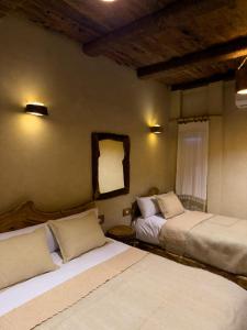 a bedroom with two beds and a mirror on the wall at Hidden Garden House in Siwa