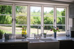 a kitchen with a sink and a large window at Challens Yarde in Midhurst