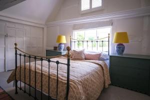 a bedroom with a bed with two lamps and a window at Challens Yarde in Midhurst