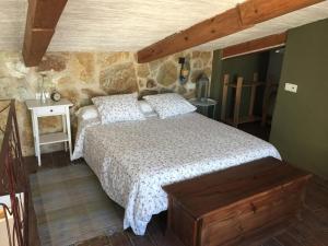 a bedroom with a bed and a stone wall at La Casa del Bachiller in Campo de Criptana
