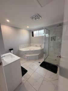 a white bathroom with a tub and a shower at The Green Shouse in Stanthorpe +19 photos