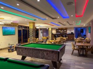 a pool table in a room with tables and chairs at Blue Orange Hotel and Towers in Shomolu