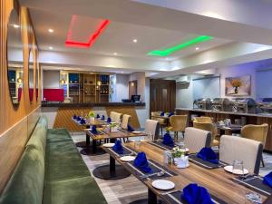 a restaurant with tables and chairs and a bar at Blue Orange Hotel and Towers in Shomolu