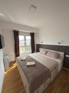 a bedroom with a large bed with two towels on it at KRUM Apartments in Kumanovo