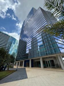 a tall building with glass windows in a city at Fusion e Vision Flats in Brasília