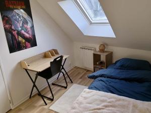 a bedroom with a bed and a desk and a skylight at Au 24 a connerre in Connerré