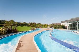 a large swimming pool with a slide in a resort at Pine Ridge B6 in Reighton
