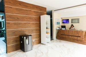a woman sitting at a counter in an office with a cash register at San Felipe Hotel in Colinas do Tocantins