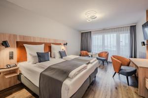 a hotel room with a large bed and a desk at Apartment-Hotel Hamburg Mitte in Hamburg