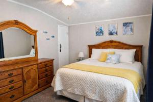 a bedroom with a bed with a dresser and a mirror at Rough River Lake Cabin Fishing in Fentress McMahan