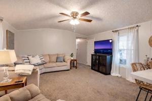 a living room with a couch and a ceiling fan at Rough River Lake Cabin Fishing in Fentress McMahan