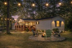 a small house with chairs and a table in the yard at Rough River Lake Cabin Fishing in Fentress McMahan