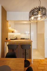 a kitchen with a bar with chairs and a chandelier at MaxInn 14 in Pirot
