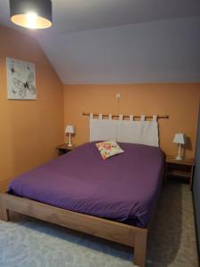 a bedroom with a bed with purple sheets and two lamps at Villa Clara in La-Roche-en-Ardenne