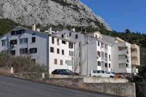 a white apartment building with a mountain in the background at Sweet Escape in Makarska