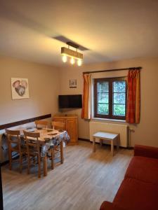 a living room with a table and a tv at Villa Clara in La-Roche-en-Ardenne