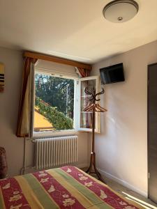 a bedroom with a bed and a window at Hotel Au Cerf in Riquewihr