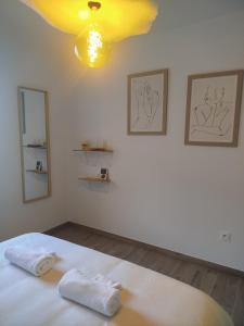 a bedroom with a bed with two towels on it at Chambres d'hôtes" Tout Simplement" in Beaurepaire