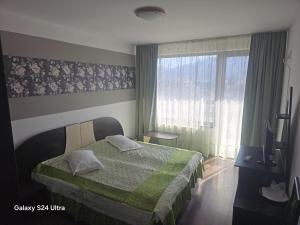 a bedroom with a bed and a large window at Pensiunea Alexia in Bistriţa