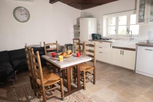 a kitchen with a wooden table and chairs in a room at Studio cosy au calme in Chillac