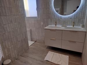 a bathroom with a sink and a mirror at Chambres d'hôtes" Tout Simplement" in Beaurepaire
