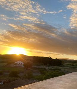 a sunset over a house with the sun in the sky at Firgrove Country Lodge in Robertson +16 photos