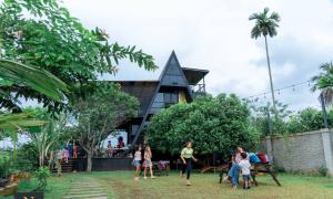 a group of people standing in the grass in front of a building at Villa Nelith in Galle