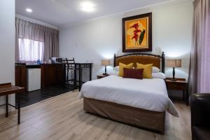 a hotel room with a bed and a kitchen at Basdenwood Hotel in Centurion +53 photos