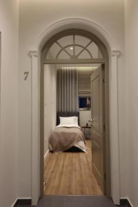 an archway leading to a bedroom with a bed at Rroji Urban Heritage - Boutique Rooms & Serviced Apartments in City Center in Shkodër