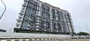 a large building with cars parked in a parking lot at D'Millenia Residences Steady in Kota Samarahan