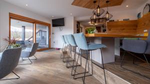 a kitchen with a bar with blue bar stools at Relax Walding in Jörgensbühl