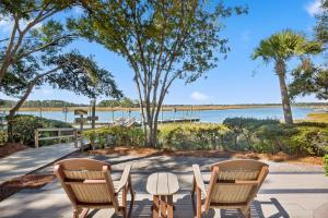 two chairs and a table in front of the water at IC106: 106 Inlet Cove in Kiawah Island