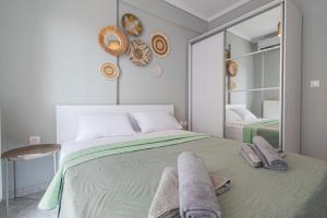 a bedroom with a large bed with towels on it at Aeris Apartment by Booking Kottas in Nea Moudania