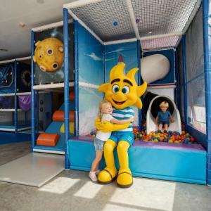 a little girl hugging a mascot in a play room at htop Olympic - Fun in Calella
