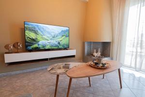a living room with a flat screen tv on a wall at Aeris Apartment by Booking Kottas in Nea Moudania