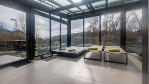a living room with large windows and a couch at Relax Walding in Jörgensbühl