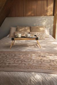 a tray with two cups on top of a bed at Sky chalé - Refúgio Da Lua in Ametista do Sul