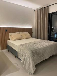 a bedroom with a large bed in a room at Cozy Moov Smart Apartamento in Cuiabá