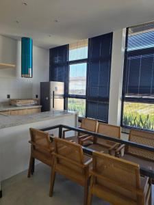a kitchen with chairs and a table and a counter at Cozy Moov Smart Apartamento in Cuiabá