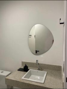 a bathroom with a sink and a mirror at Cozy Moov Smart Apartamento in Cuiabá +16 photos