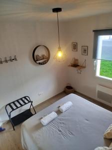 a bedroom with a bed and a mirror and a window at Chambres d'hôtes" Tout Simplement" in Beaurepaire