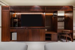 a room with a tv and a desk and a bed at Mansion Bridge Cheonan in Cheonan