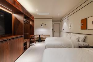 a hotel room with two beds and a flat screen tv at Mansion Bridge Cheonan in Cheonan +88 photos