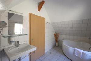 a bathroom with a sink and a bath tub at Ferien Hotel Villa Südharz in Sülzhayn +35 photos