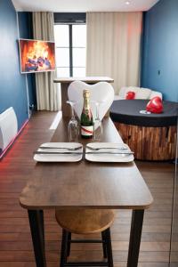 a wooden table with a bottle of wine on it at L'Envers SPA - Suite Romantique Metz Centre in Metz