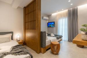 a hotel room with two beds and a tv at K35 Apartments in Preveza