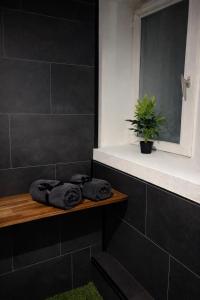 a bathroom with black tiles and a window and towels at L'Envers SPA - Suite Romantique Metz Centre in Metz +18 photos