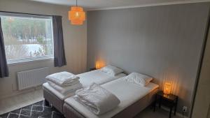 a bedroom with two twin beds and a window at Lagom huset in Årjäng