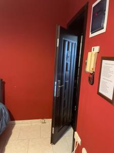 a black door in a room with a red wall at Serres central house in Serres