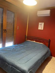 a bed in a room with a red wall at Serres central house in Serres
